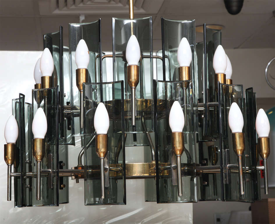 Chandelier with brass frame. Contains 24-lights, arms in brass and metal. The curved diffusers are in smoked grey glass.  In the style of Fontana Arte.

Original canopy, recently re-wired.
