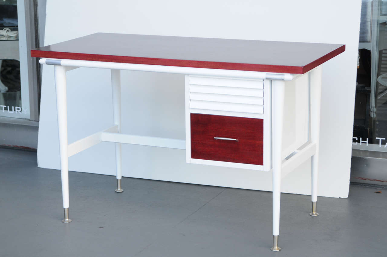 The louvered drawer gives the impression that could be made by America of Martinsville. Beautifully refinished, top and drawer front and back were refinished in red wine stain; the body is refinish in high white gloss. Handle and Shoes are original