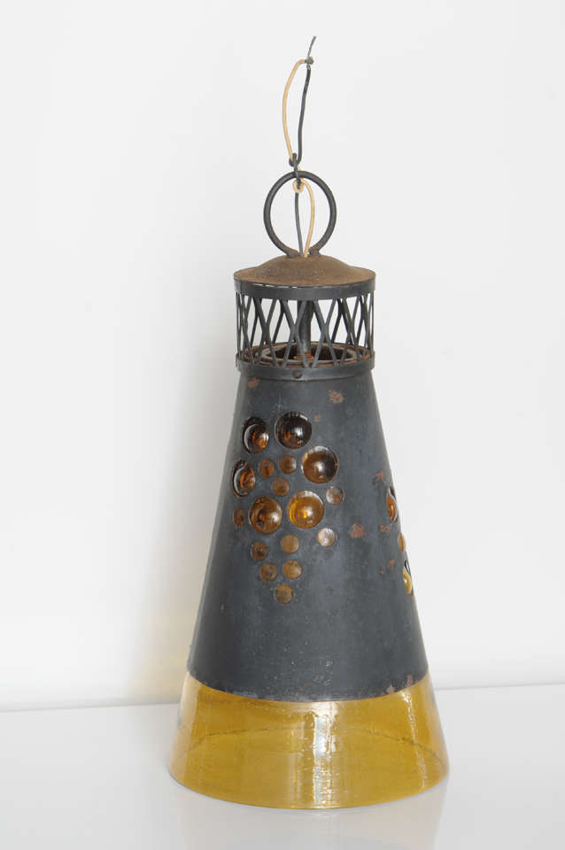 Made of weathered metal and yellow hand-blown glass.  Single bulb casts a beautiful golden glow.  Hardwired.  
