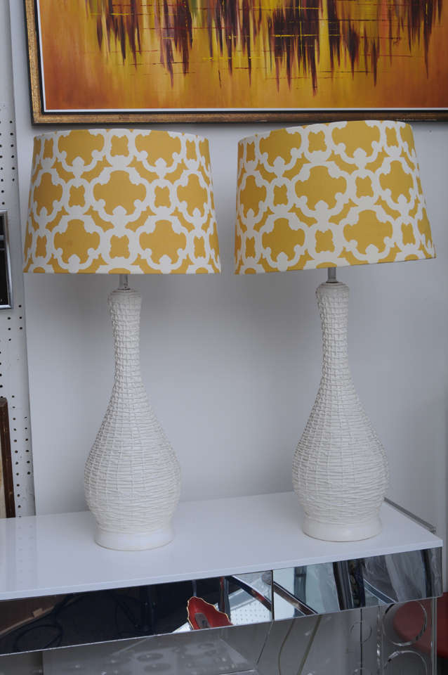 Woven, painted rattan covers on plaster.  These eye-catching lamps, organic look, but heavy on weight that giving them a beautiful stability.