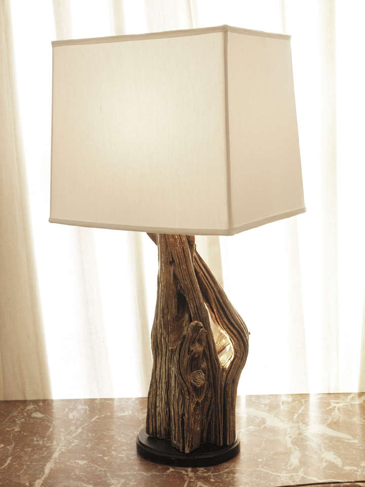 Table lamp in gilt plaster of naturalistic tree-trunk form with ovoid painted wooden base; two light sources: one at the shade, another nestled within the 'trunk'; custom ivory silk shade