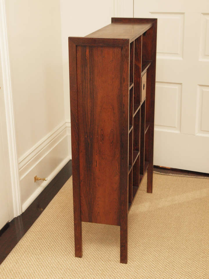 Handsome bookcase in rosewood with one drawer accessible from either side.