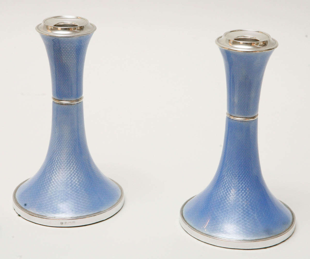 A stunning pair of periwinkle guilloche enamel over sterling silver candlesticks by Charles S. Green & Co. Marked with the sterling assay mark, maker's hallmark and date mark (see Image 4).