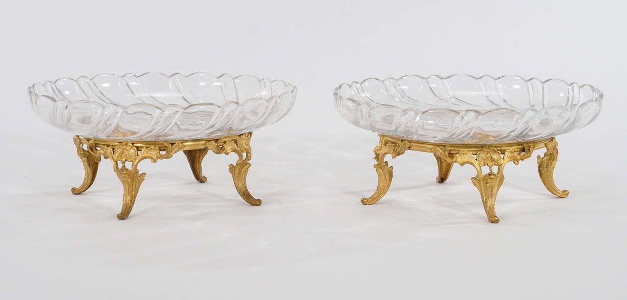 An extraordinary matched pair of signed Baccarat tazzas featuring hand blown and cut crystal bowls with petal cut rims and star burst center. The elaborate stand is bronze with gold d'ore finish. The condition is superb and the large size makes them