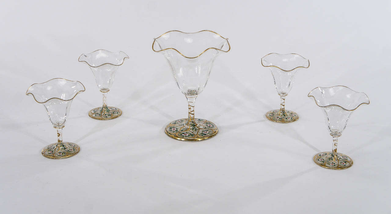 Cet ensemble de cinq vases en cristal soufflé à la bouche, de style Art Nouveau, constitue un arrangement charmant et inhabituel, utilisé comme pièce centrale ou exposé sur une cheminée. Chacun des quatre petits vases peut entourer le cinquième