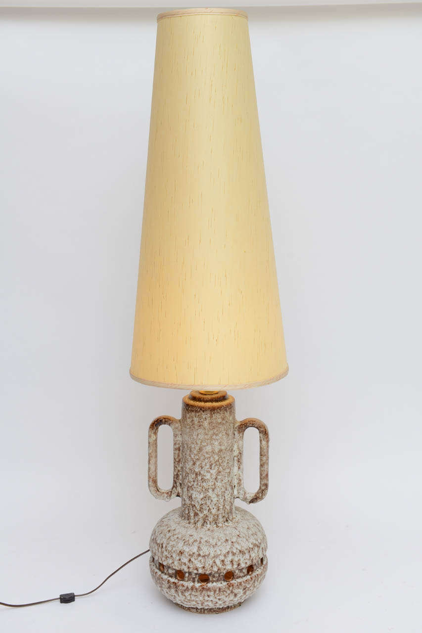 Large and monumental and tall enough to be a floor lamp, this two handled urn form pottery table lamp has an incredible thick frothy white over brown lava glaze and is spectacular not only for its size. Besides the main light behind the tall shade,