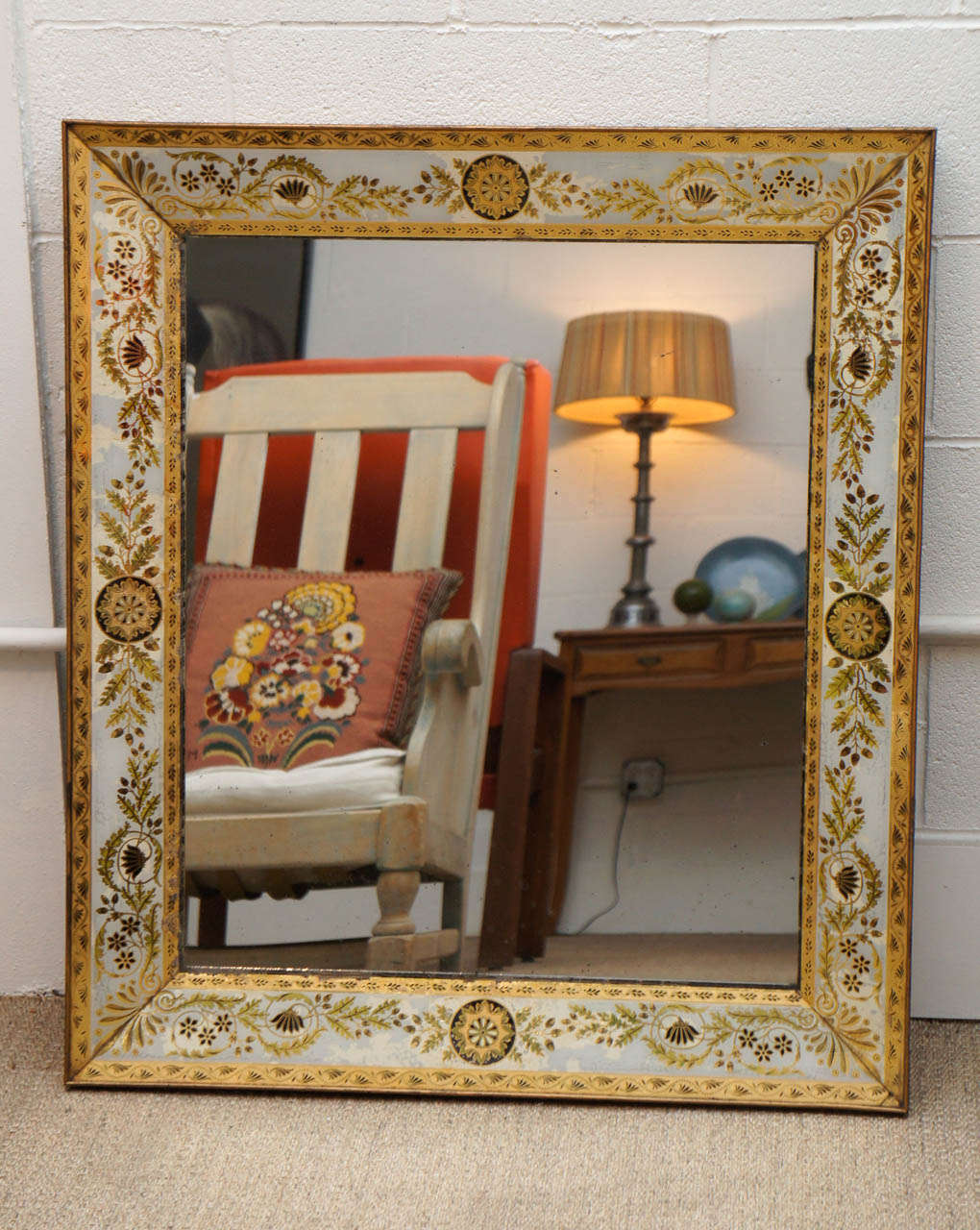 Here is an elegant Regency style eglomise mirror with a matched medallion and leaf motif. The colors are beautiful in gold white and brown.