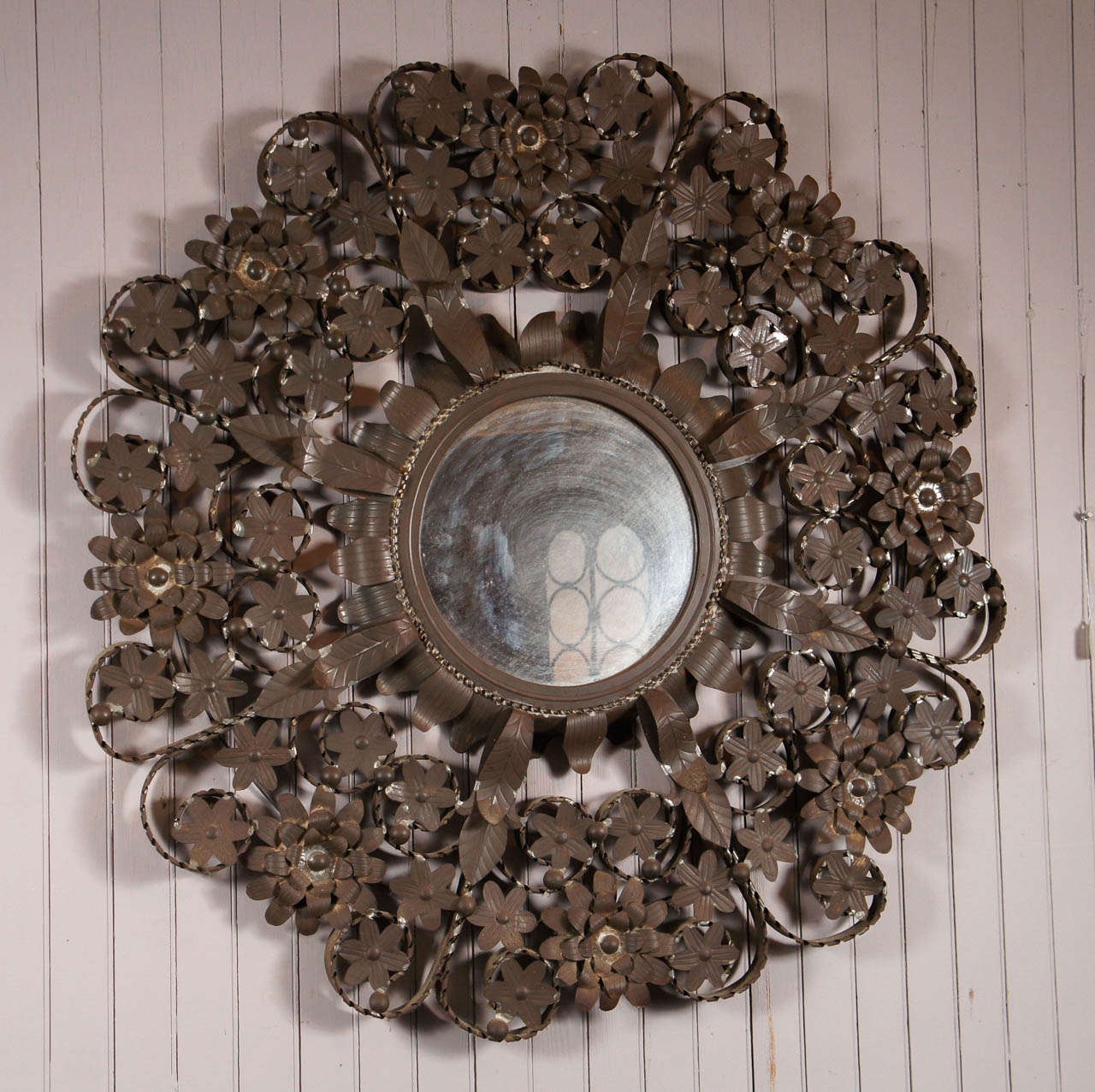 work intensive mexican tin mirror - original mirror glass - surrounded by rings of small tin flowers - larger flowers crown each of the eight segments