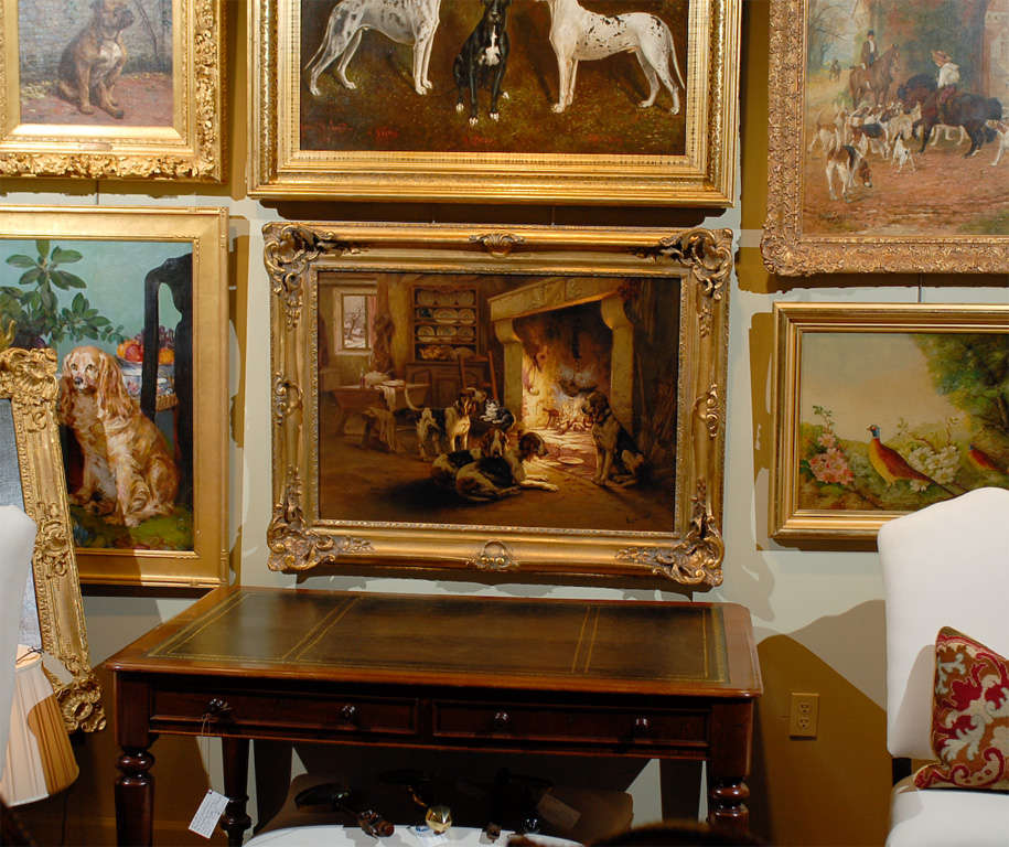 This oil on canvas painting by Louis Lartigau is titled Chiens de Chasse Devant la Cheminée (hunting dogs in front of the fireplace). Dated from the turn of the century, this exquisite scene captures a particular moment. Slightly off center, the