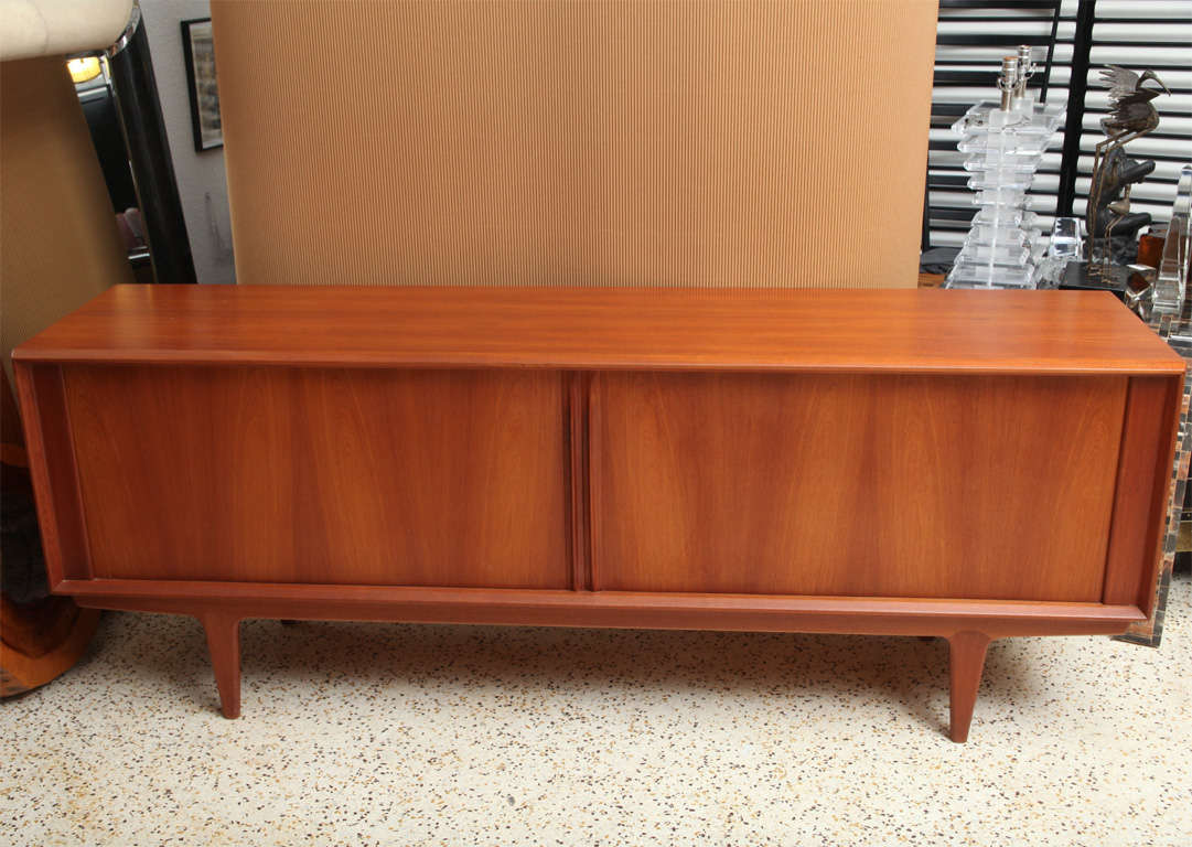Sliding tambour doors hide all the drawers and shelves in this clean-lined 60's Danish credenza, making it all about the wood - strikingly grained solid teak! Makes a great media cabinet, too...
