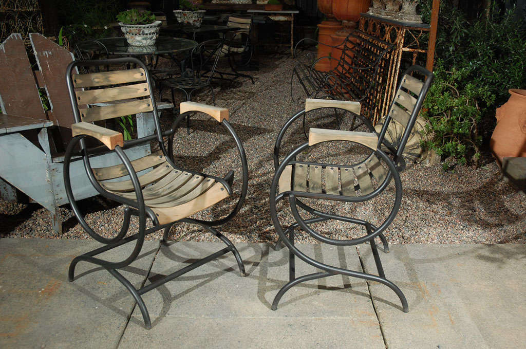 A set of four chairs with a fabulous escargot circular arm design and shaped wood slat seats. Great occasional accent chairs or garden chairs.