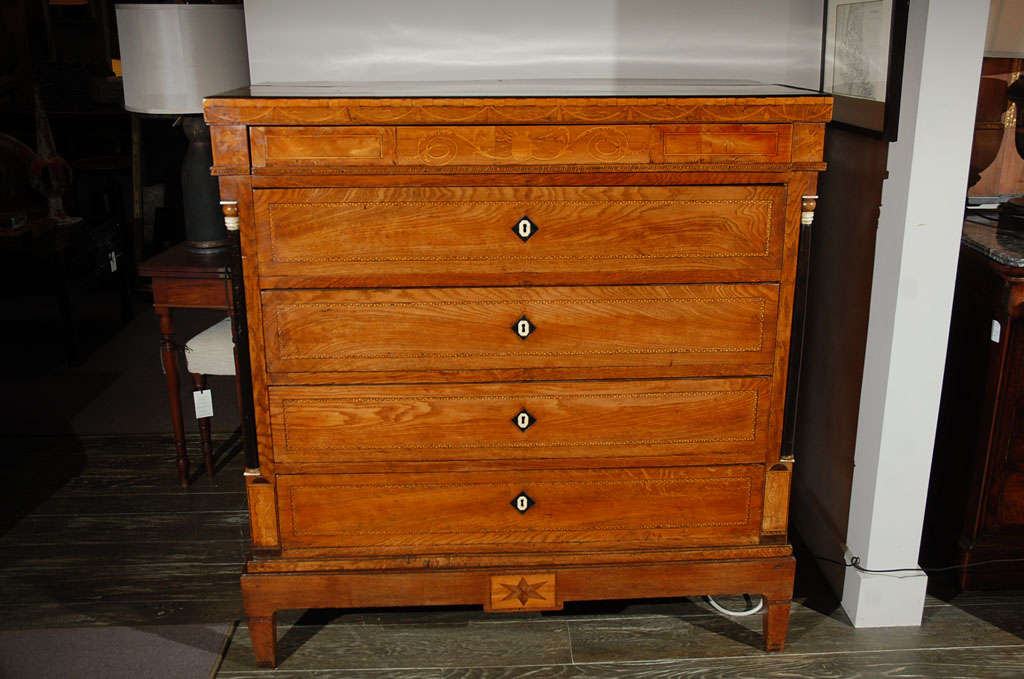 1830s Danish five-drawer inlaid commode. Piece has a beautifully inlaid frieze, ebonized side columns, decorative inlaid escutcheons, and a tapered foot base. Beautiful detailed dresser or chest of drawers.