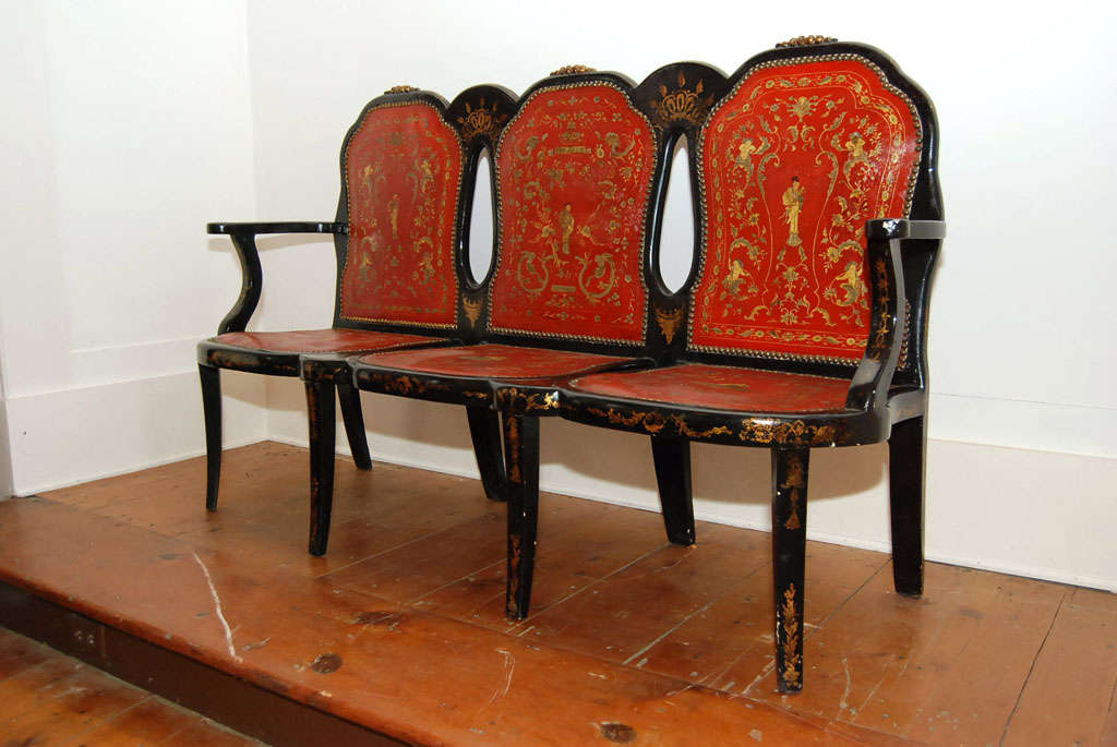 Rare Continental black lacquer and parcel-gilt triple back settee or hall bench. Foliate carving on each crest rail over three gilded and embossed red leather backs and seats, all with chinoiserie decoration.