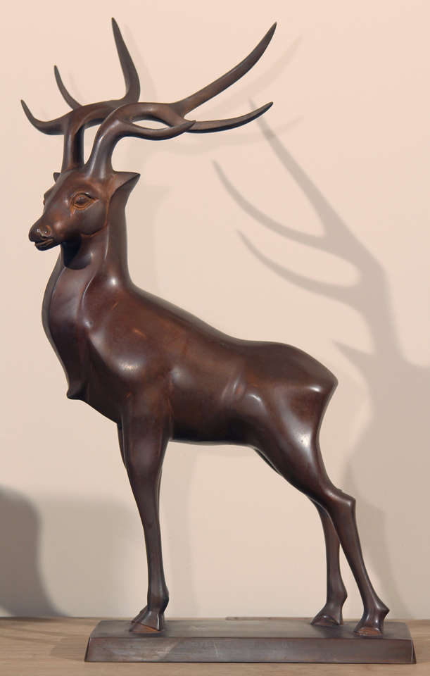 Stylized bronze stag of the early Showa era (1926-1989). Shows deep Deco influences that began in the Taisho era and came to fruition in the early thirties when this piece was created. 
Maker's mark on the belly of the sculpture.