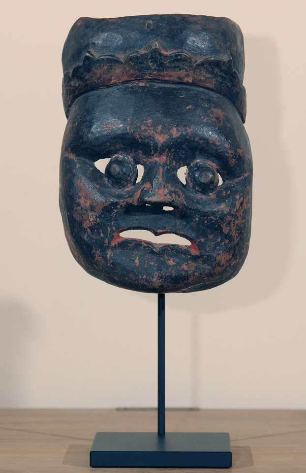 Chinese Taoist ceremonial wood mask on custom metal stand. This type of mask was used by shaman in animistic Nu religious ceremonies when invoking gods to assist in earthly matters. Some traces of red pigment remain, overall dark patina.
Early to