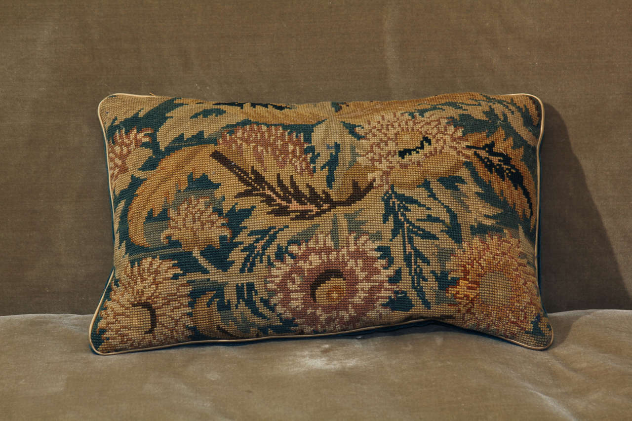 A pillow made from and antique fragment of needlepoint backed with mohair velvet and feather down filled.