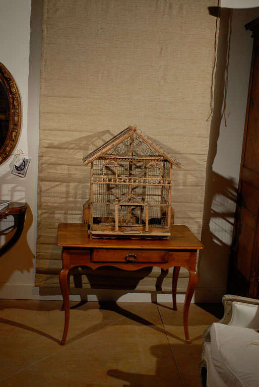 A French rustic Napoléon III period wooden birdcage from the mid 19th century, with scrolling metal accents and baluster motifs. Created in France during the third quarter of the 19th century, this wooden birdcage, shaped as an elegant house, is