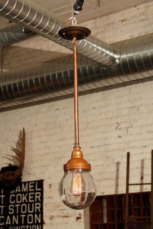 Threaded copper top stamped Benjamin, round glass globe, and swivel top mount.  Elegant industrial statement.