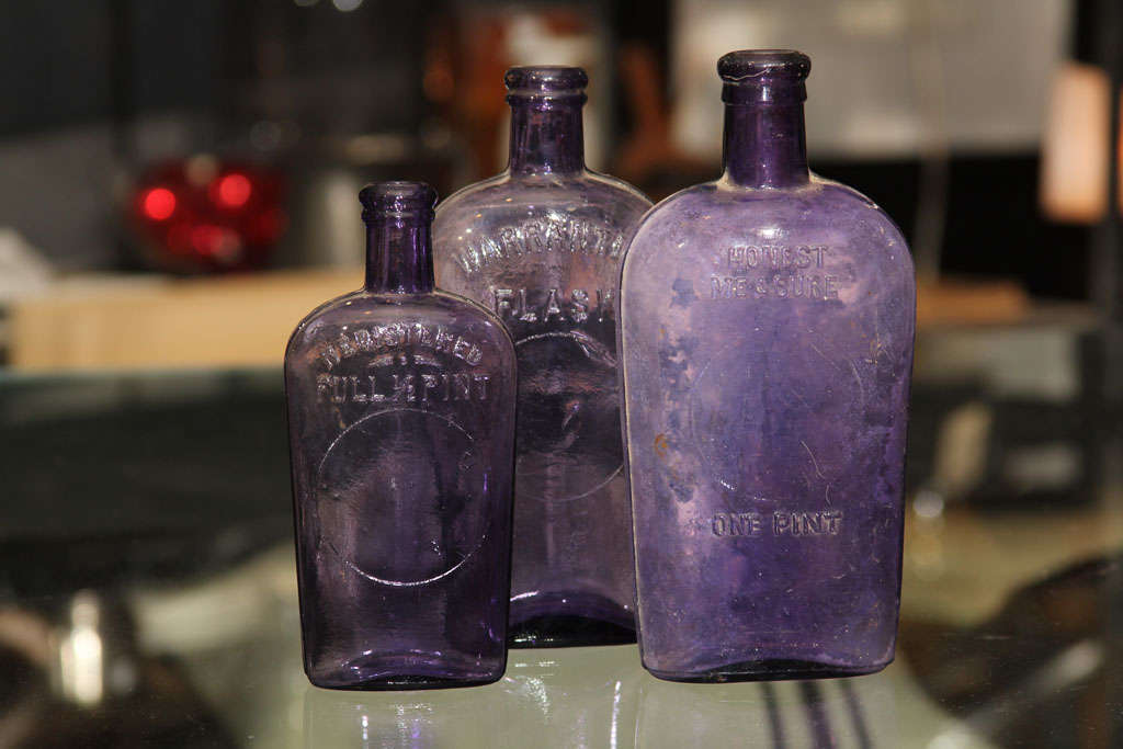 set of 3 purple bottles, probably held liquor.  These bottles started out clear, manganese in the glass turns them purple with age and light.