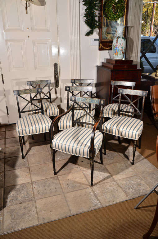 a set of six English Regency side chairs, black with delicate painted designs on the crest rail, back splat and turned legs, striped blue and white silk upholstery. <br />
<br />
$8,750 for the set of six<br />
<br />
one single arm chair, 20