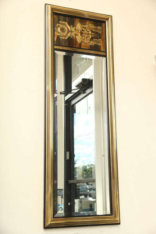 This sensational mirror is the perfect addition to any space. It could be hung horizontal or vertical with its weighted artistic etching.  It has original beveled glass and a simplistic gold and black frame that compliments the decorative etched