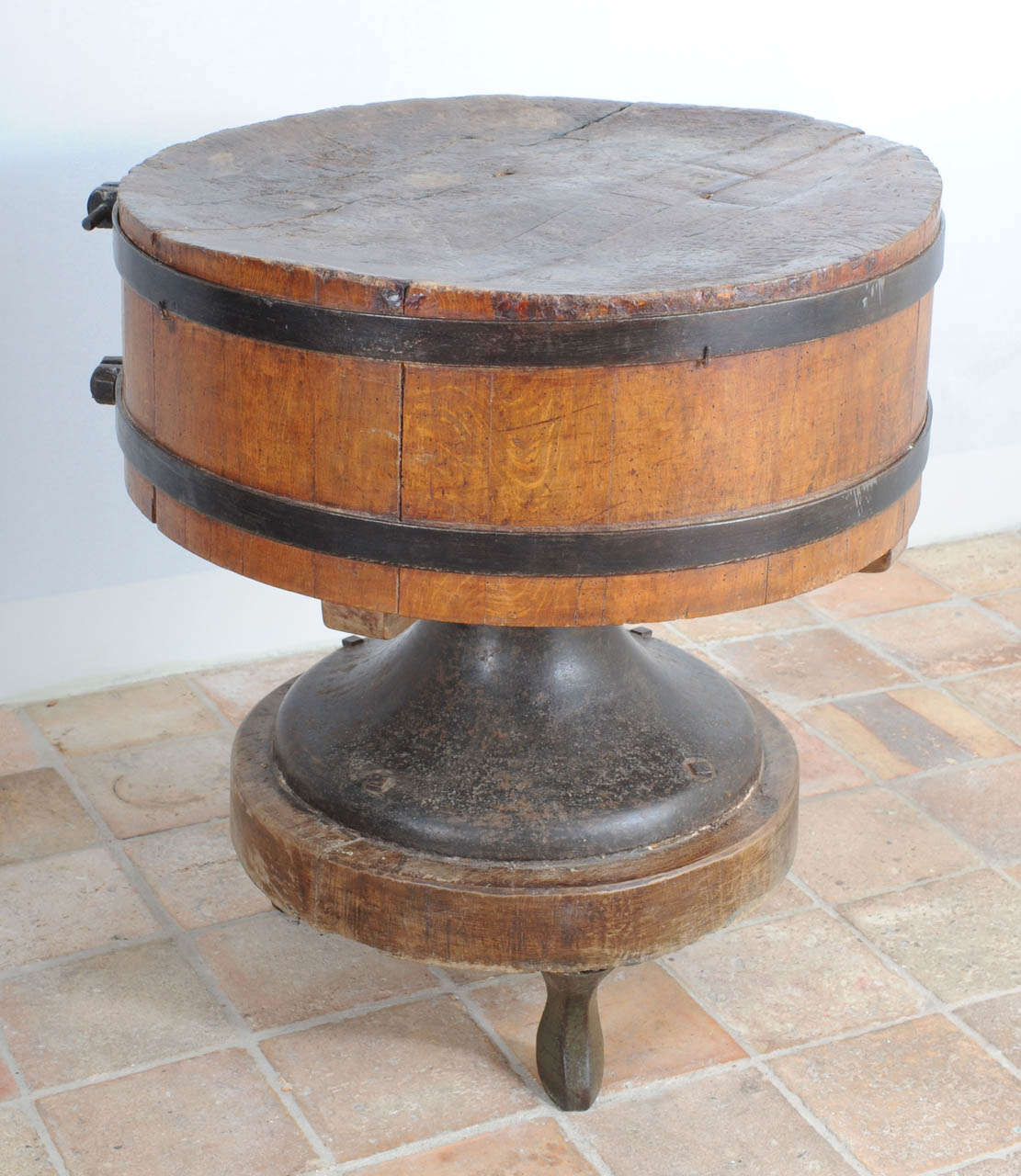 A very rare round wooden butchers block with wrought-iron straps and on a cast-iron base and feet. 
The round shape suggests it has been used as a centre piece. 
Found in Milan, probably to cut Parma hams.The diabolic shaped base is a rarity we