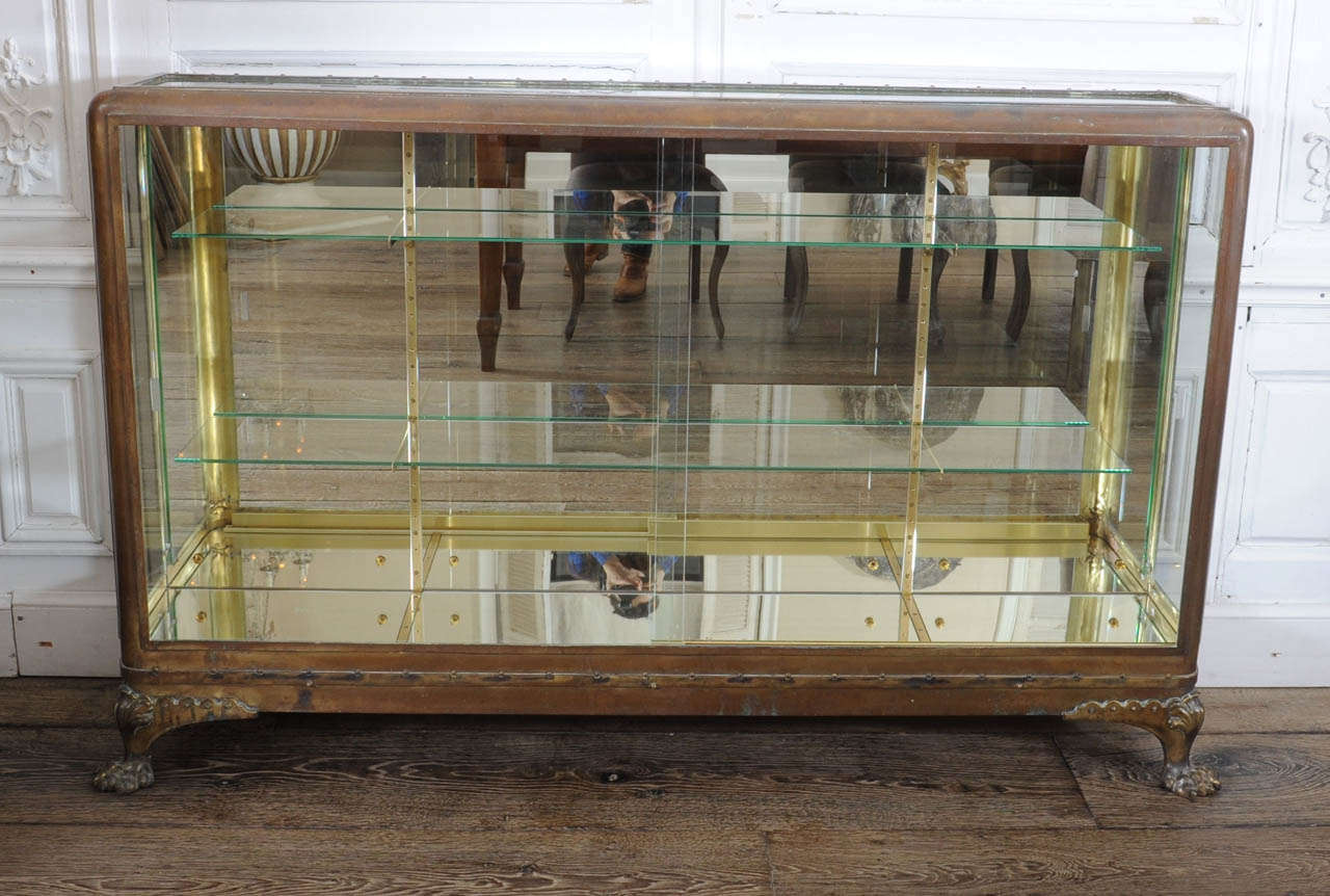 With 2 shelves, the back and bottom with mirrored glass, the back in oak.  
Back complete replaced, the brass with a beautiful patina.