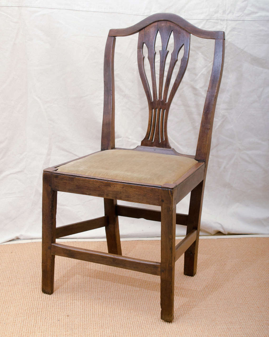 English late 18th century oak arrow cut-out -- shield back -- Hepplewhite design country side chair with slip seat. The square slightly tapered legs are joined by stretchers on all four legs. Handy useful chair for a writing table or extra pull up.