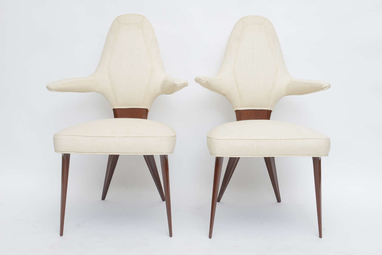 The upholstered back with channel seat over an x framework with splayed tapering legs can be sold as pairs.