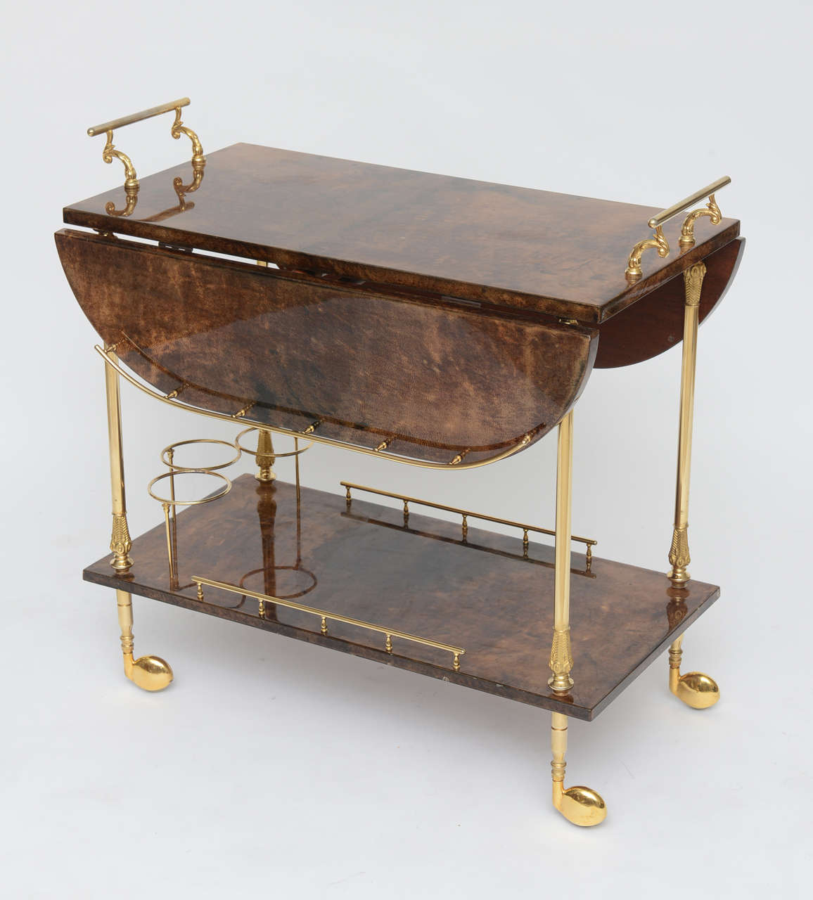 Handsome Tura parchment bar cart in exceptionally good original vintage condition. Brown lacquered goatskin with polished brass hardware. Depth expands from 16