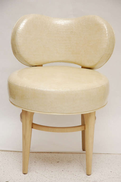 A pretty swiveling vanity stool by Paul Frankl for Johnson Furniture, newly upholstered in croco-embossed patent cream leather with cerused oak finish.