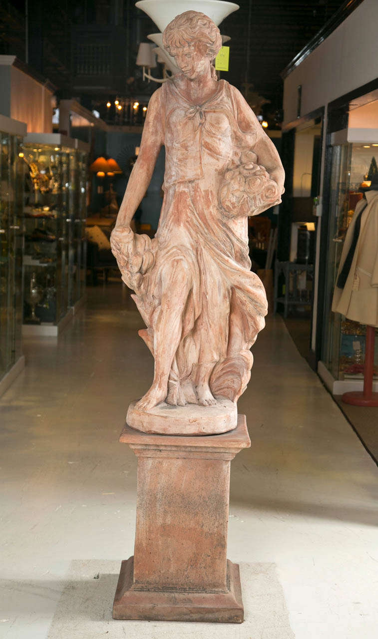 20th century terracotta statue on stand.