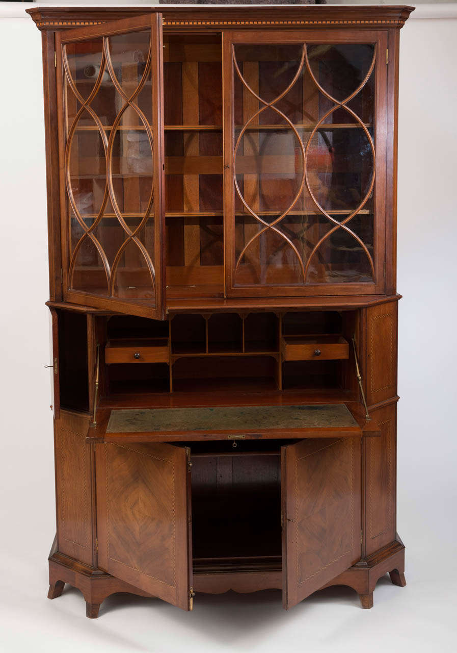 A Mahogany Secretaire Cabinet by George Jack (1855-1931) for Morris & Co.
Inlaid with chequered and line stringing, with astragal glazed cupboard doors. A fall front enclosing a leather inset reverse with pigeon holes. Flanked by canted