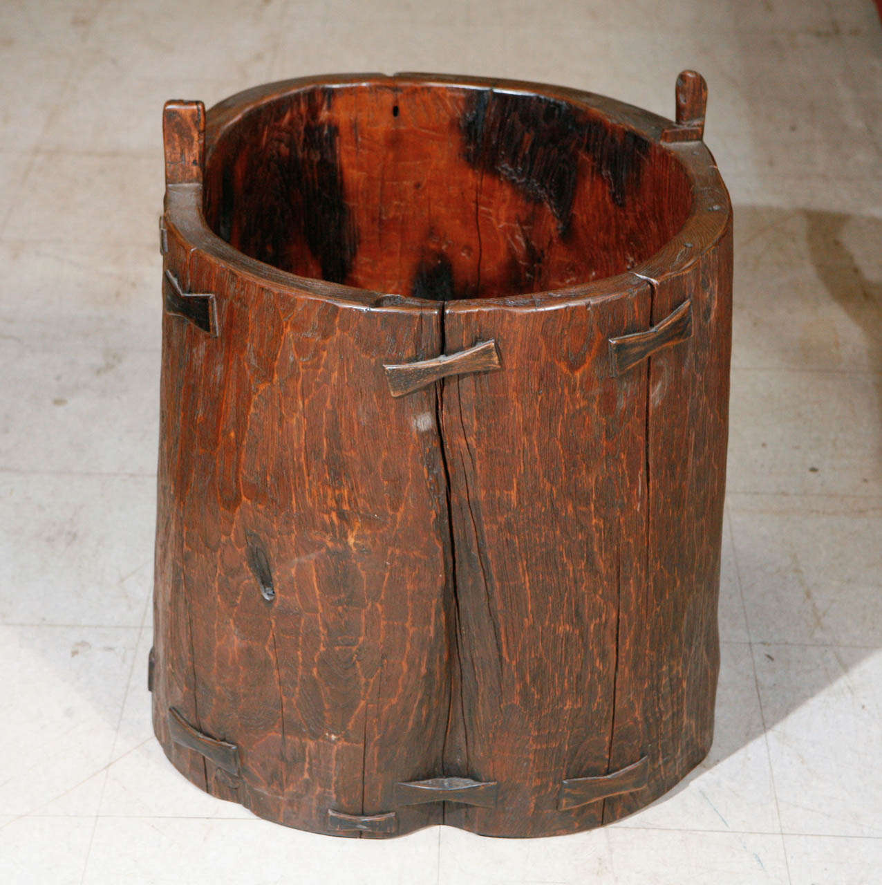 Rare and unusual antique granary vessel of thick teak hardwood with thirteen butterfly inserts, rural Java, circa 19th Century.