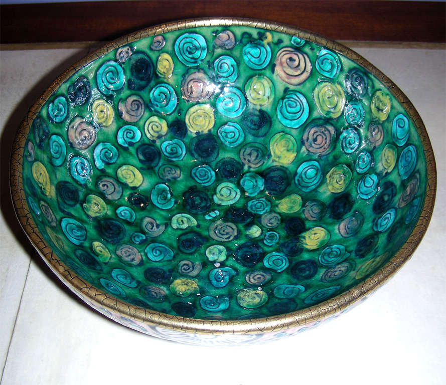 Impressive circa 1911 faïence bowl set on a base, decorated with stylized pink and blue patterns on the outside; interior decor in stylized roses on a green background. Hollowed-out monogram under the base of André Metthey.

