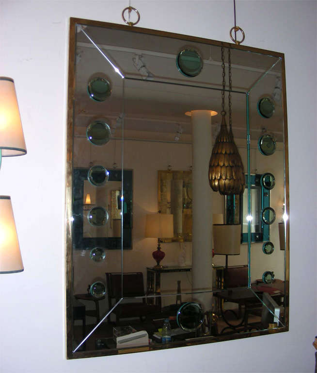 Mirror made of increasing round beveled green mirror decorating the side of the main mirror with a frame and rings in gold bronze.