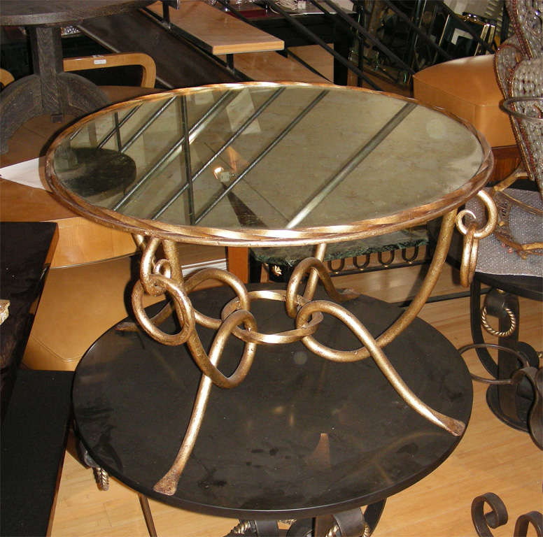Gilded iron round coffee table with top in mirror.
