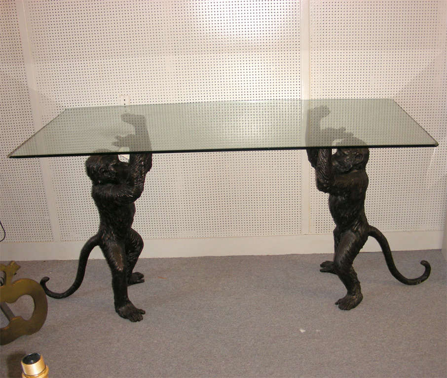 1980s console table, supported by two patinated bronze monkeys. Glass top surface dimensions: Height 78 cm., length 146 cm., depth 69 cm. Dimensions below are of monkeys.
Glass must be changed