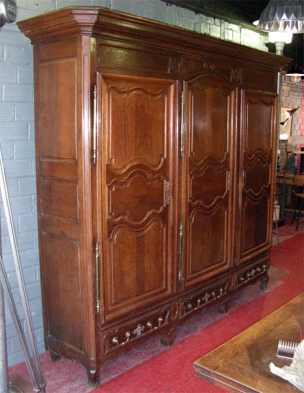 Rare model 18th century armoire in solid oak, with three doors and three drawers, with original lock. Original keys for the lateral doors; no keys for the drawers. Central separating plank; six shelves are available. From the Lorraine region of