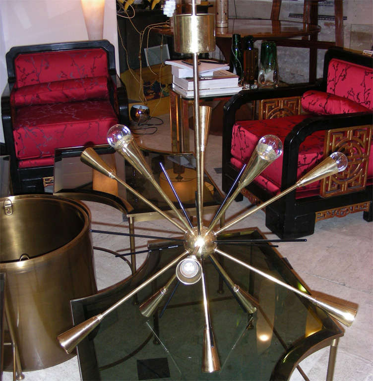1950s sputnik-shaped chandelier by Stilnovo in gilded brass with shafts in black metal. Eight lights. Wired for European use.