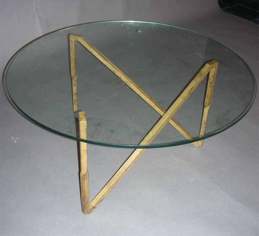 1950s coffee table with base in wrought iron gilded with gold leaf; top surface in glass.