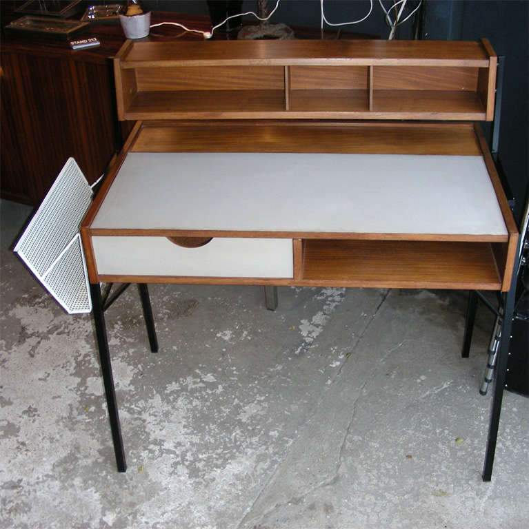 1950-1960 desk by Cees Braakman edited by Pastoe, in the style of George Nelson. Reversible magazine rack in pierced white metal. Black metal legs; one drawer; flap-up top surface. Height of top surface: 76 cm. Heigh below is with top rack. Length