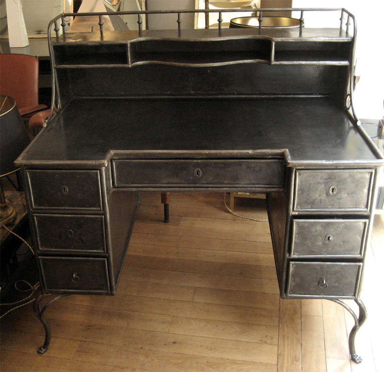 Handsome 1830s polished metal desk with seven drawers and clawed legs.