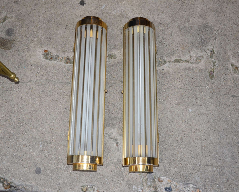Eight 1950s sconces in the style of Genet et Michon, made of clear and frosted glass tubes held by gilded brass; neon lights. Could be sold by four, but price indicated is for the eight.