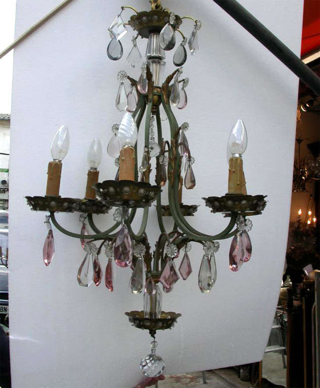 1920s chandelier and two matching sconces attributed to Maison Baguès. Iron structure, drops in mauve and clear glass. Chandelier has six branches; sconces have two. Sconces height 32 cm., length 30 cm., depth 16 cm. Dimensions of chandelier are