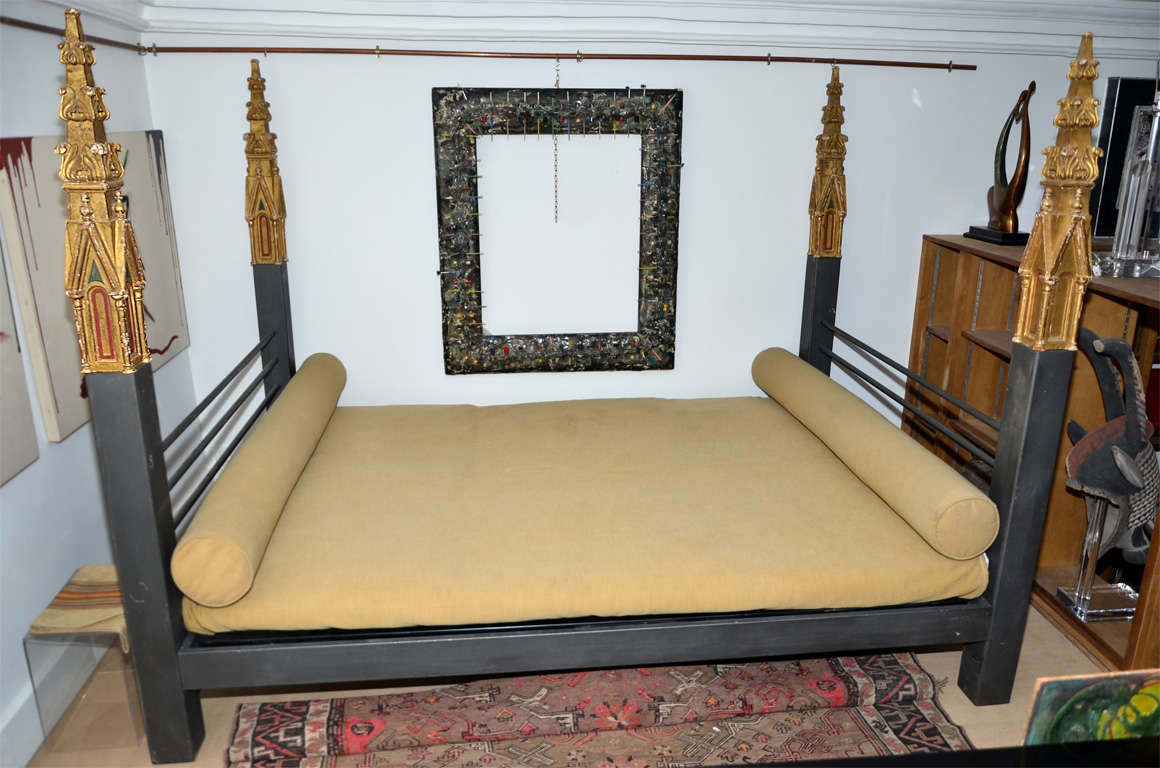 A circa 1980  italian iron bed  with 4  "steeples " carved  in wood with gold leaf and enamel : 4 architectural  decoration from a 19th century  Italian library or a  pharmacy in "neogothic"  style.
The finish of the metal is in