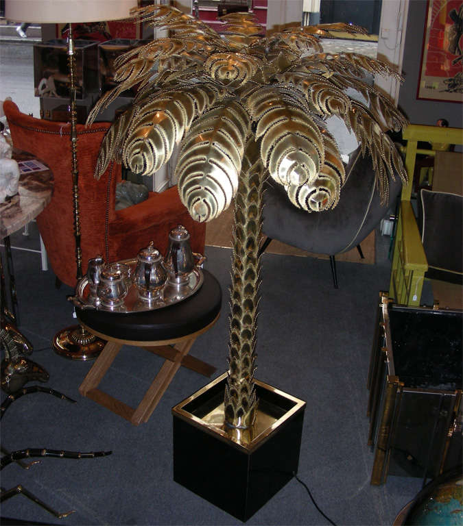 1970s palm-tree floor lamp attributed to Maison Jansen in cut-up brass, on a black plywood base edged in gilded brass. One central light and four more in the leaves.