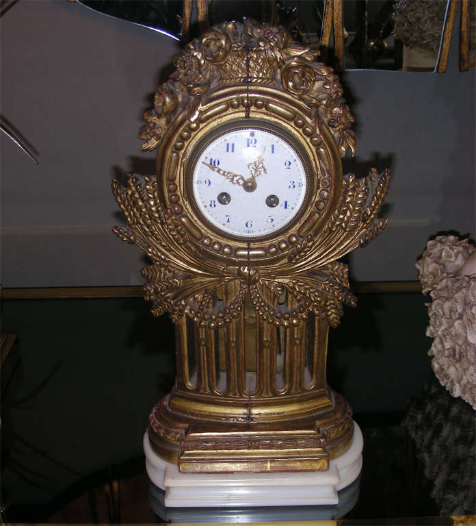 1930s carved and gilded wood clock on a marble base, in the style of Jaillot or Dufrêne.