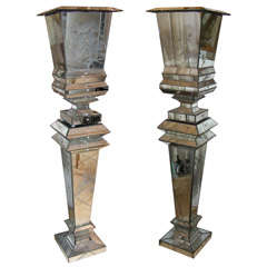 Pair of stands with vases in mirror.