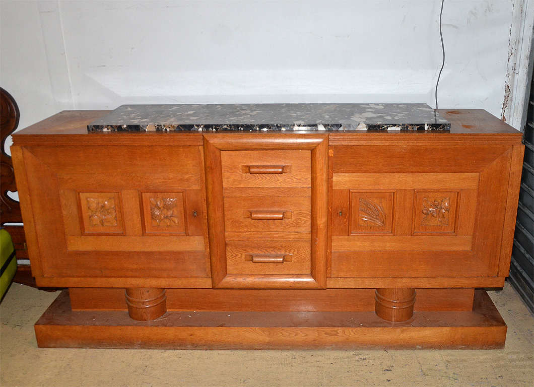 Large oak sideboard with carved door panels of ears of wheat, hazelnut branches and other fruits and flowers. Drawer handles carved winding. Beautiful quality of wood and workmanship.